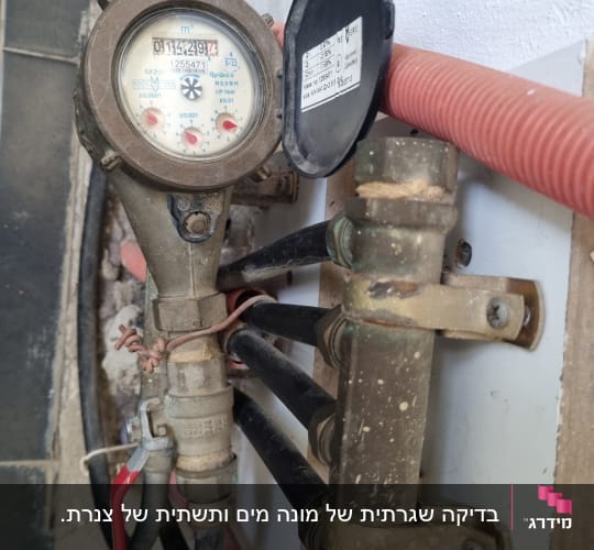 מונה מים עם צינורות וברז אדום